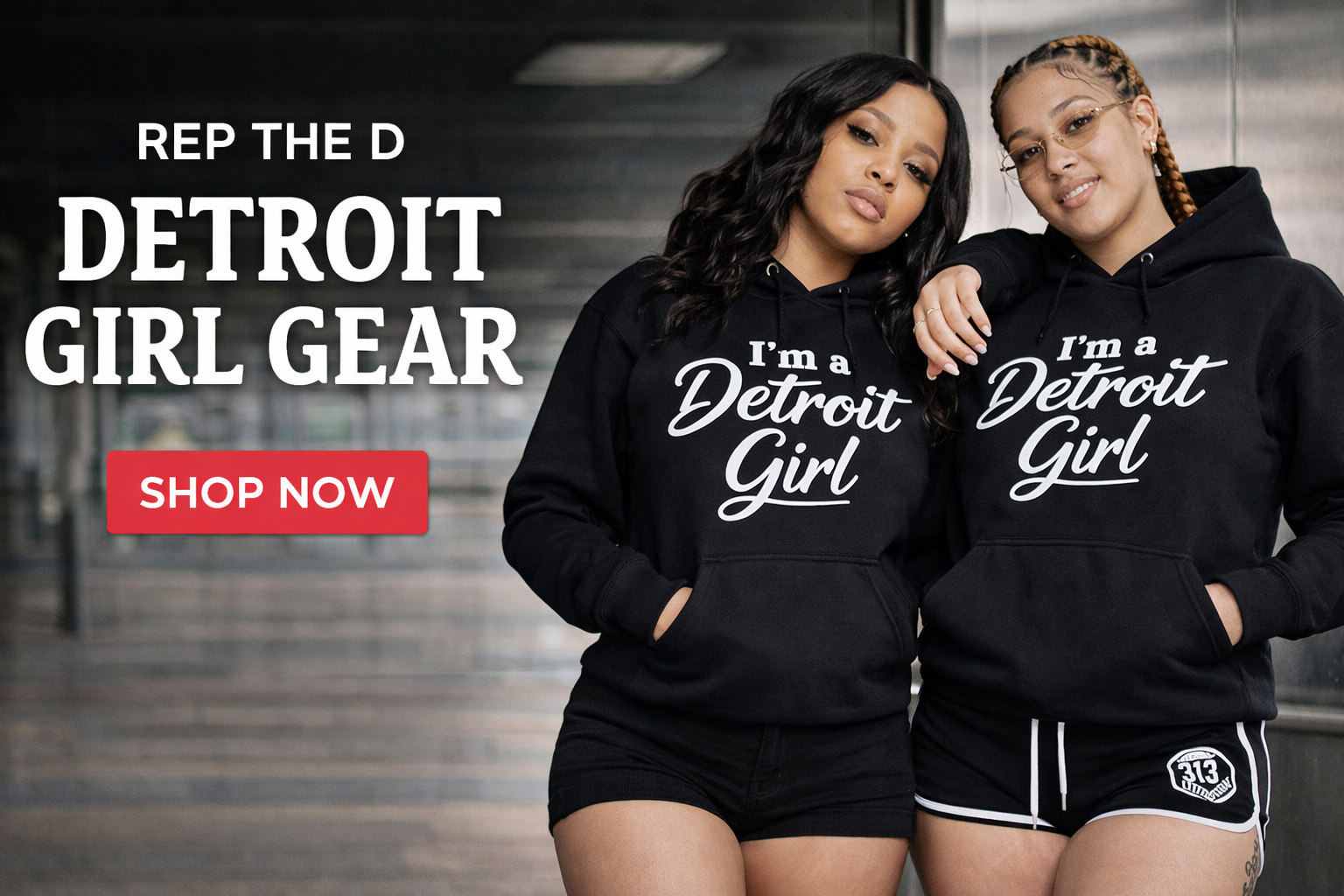 Two women wearing black hoodies with 'I'm a Detroit Girl' text, standing in front of a blurred indoor background.