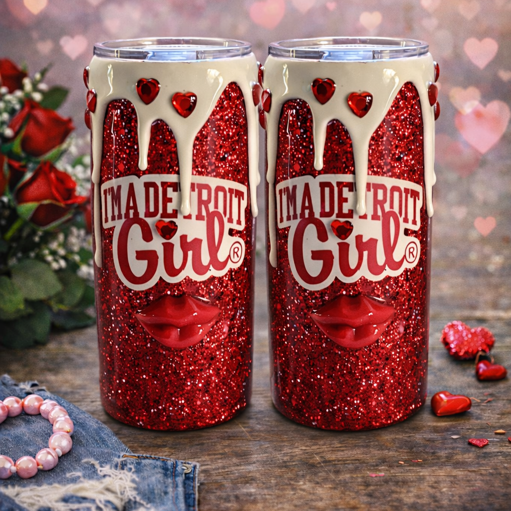 Two red glittery tumblers with 'I'm a Detroit Girl' text on a wooden surface with hearts and flowers in the background.