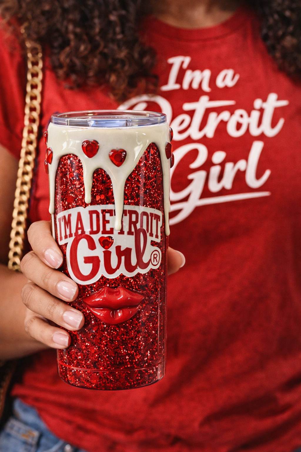 Person wearing a 'I'm a Detroit Girl' shirt holding a red glittery tumbler.