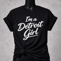 Black t-shirt with 'I'm a Detroit Girl' text on a gray background