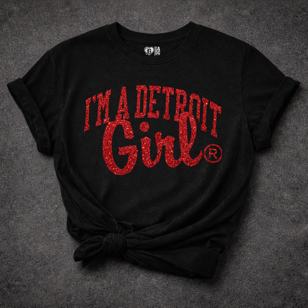 Black t-shirt with red text 'I'm a Detroit Girl' on a textured gray background